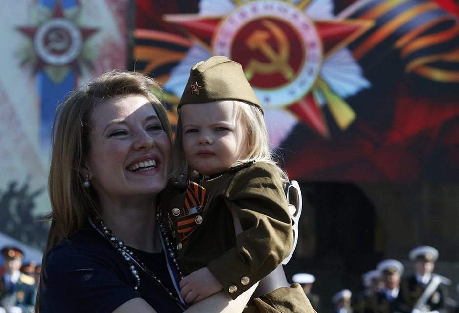 A woman and a girl dressed in historical Red Army uniform, wait before watching the Victory Day parade, marking the 71st anniversary of the victory over Nazi Germany in World War Two, at Red Square in Moscow, Russia, May 9, 2016. REUTERS/Grigory Dukor